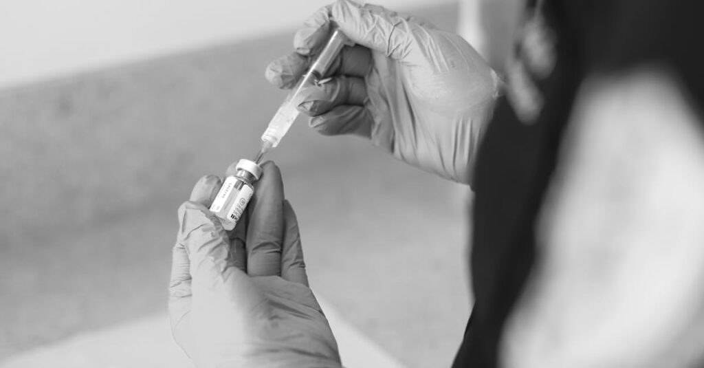 pexels-photo-27925592-27925592 Un trabajador de la salud prepara una jeringa con medicamento en un entorno clínico.